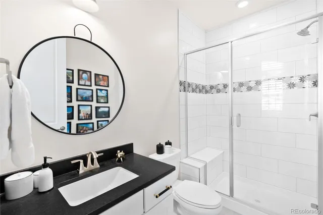 a bathroom with a sink vanity mirror and toilet