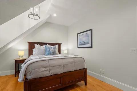 a bedroom with a bed and wooden floor