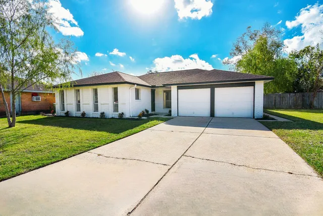 a front view of a house with a garden and yard
