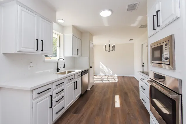 a kitchen with stainless steel appliances sink stove top oven and cabinets
