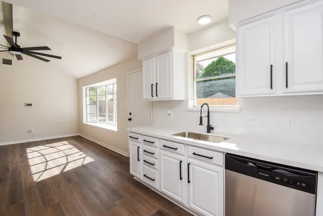 a kitchen with appliances cabinets a window and a counter space