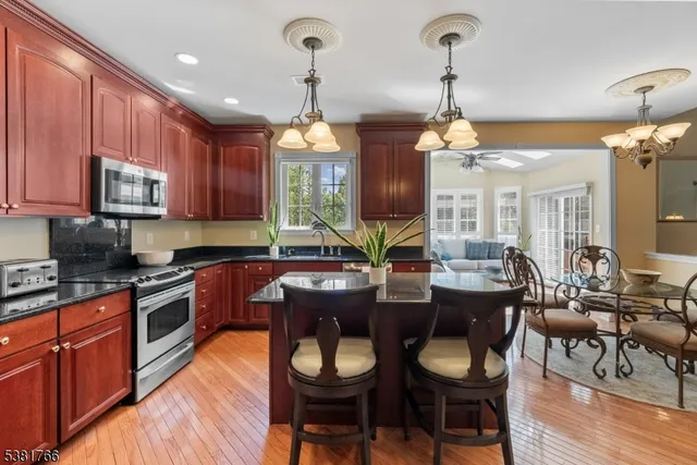 a kitchen with granite countertop wooden floors cabinets and dining table