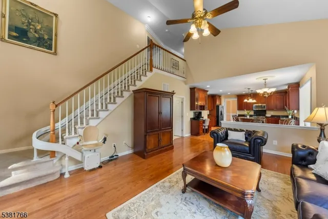 a living room with furniture and a dining table with wooden floor