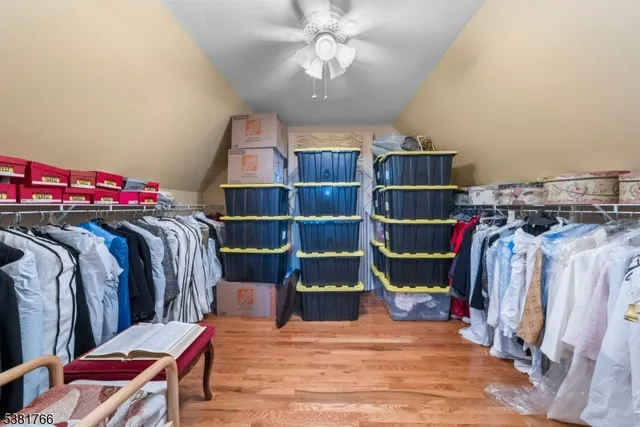 a view of walk in closet with clothes and shoes