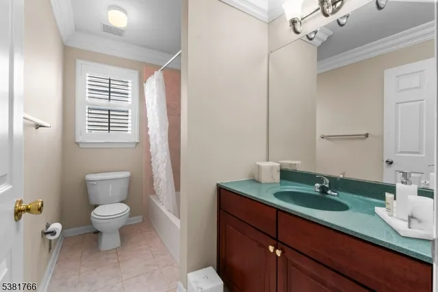 a bathroom with a granite countertop sink a toilet a mirror and shower