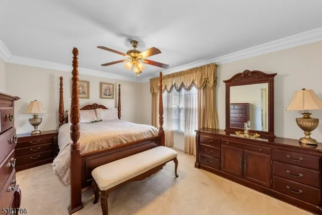 a bedroom with a bed and a large mirror on the dresser