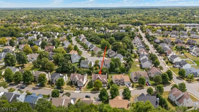 an aerial view of residential houses with outdoor space and trees