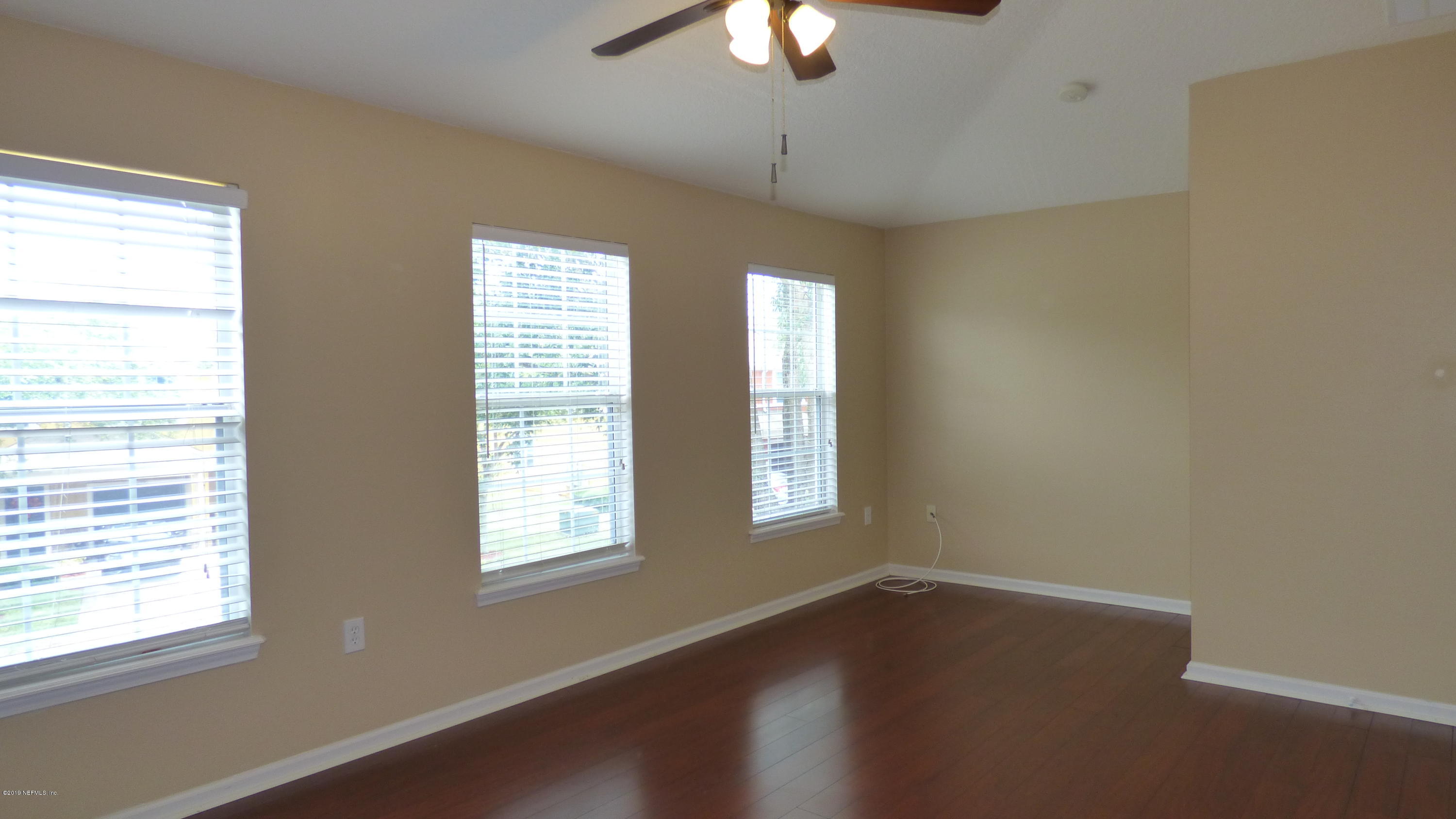 12989 Spring Rain Road Jacksonville, FL 32258 - Photo 8 of 20 a view of an empty room with wooden floor and a window