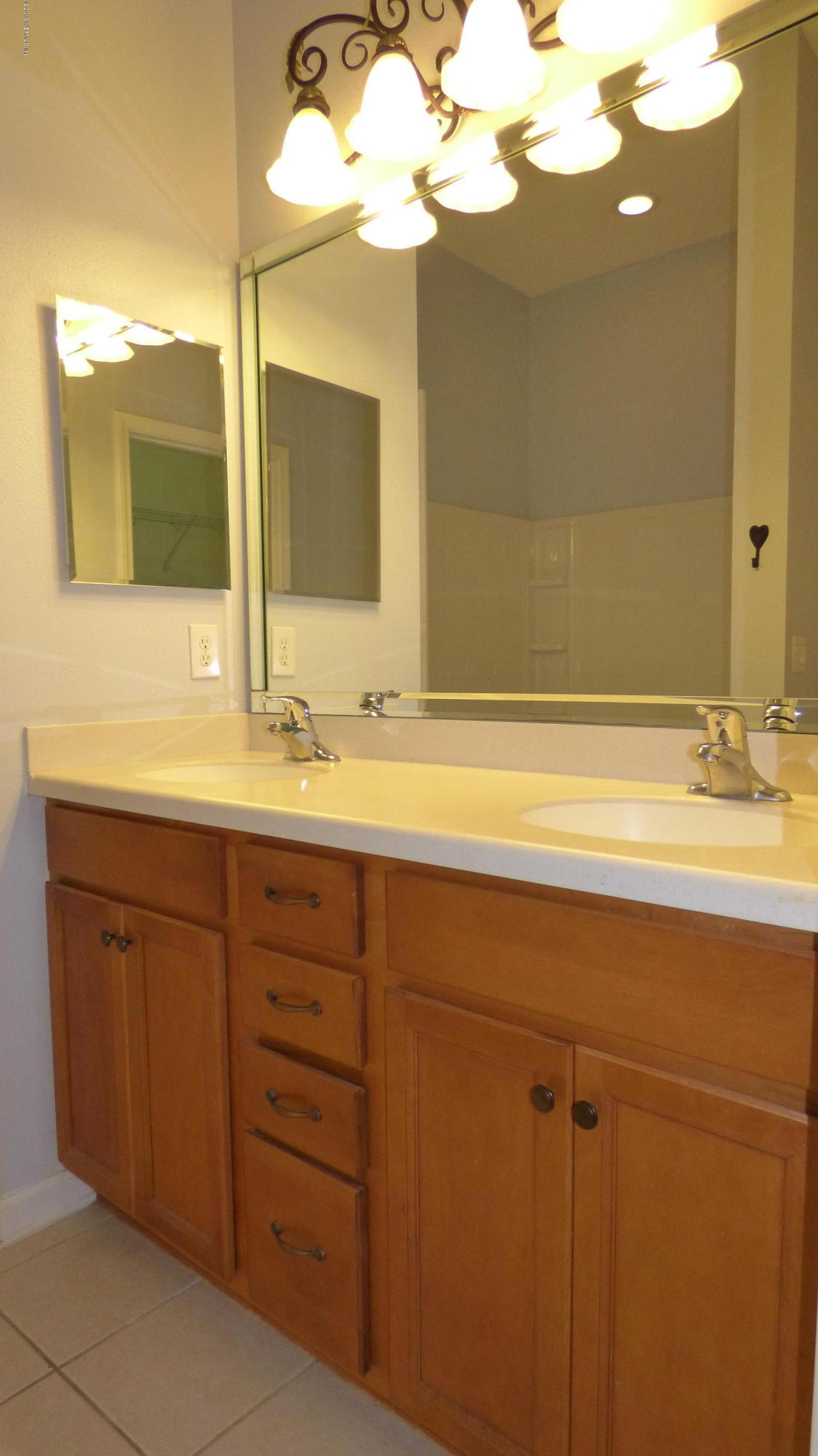 12989 Spring Rain Road Jacksonville, FL 32258 - Photo 10 of 20 a bathroom with a sink vanity and a mirror