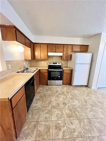 a kitchen with a stove top oven sink and cabinets