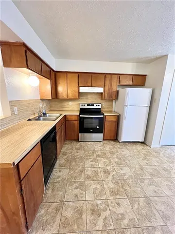 a kitchen with a stove top oven sink and cabinets
