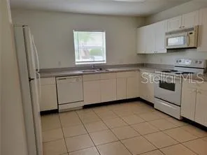 a kitchen with stainless steel appliances granite countertop a sink stove and a refrigerator