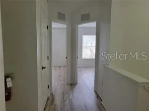 a view of hallway with wooden floor