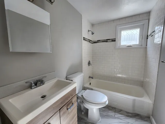 a bathroom with a sink mirror toilet and bathtub