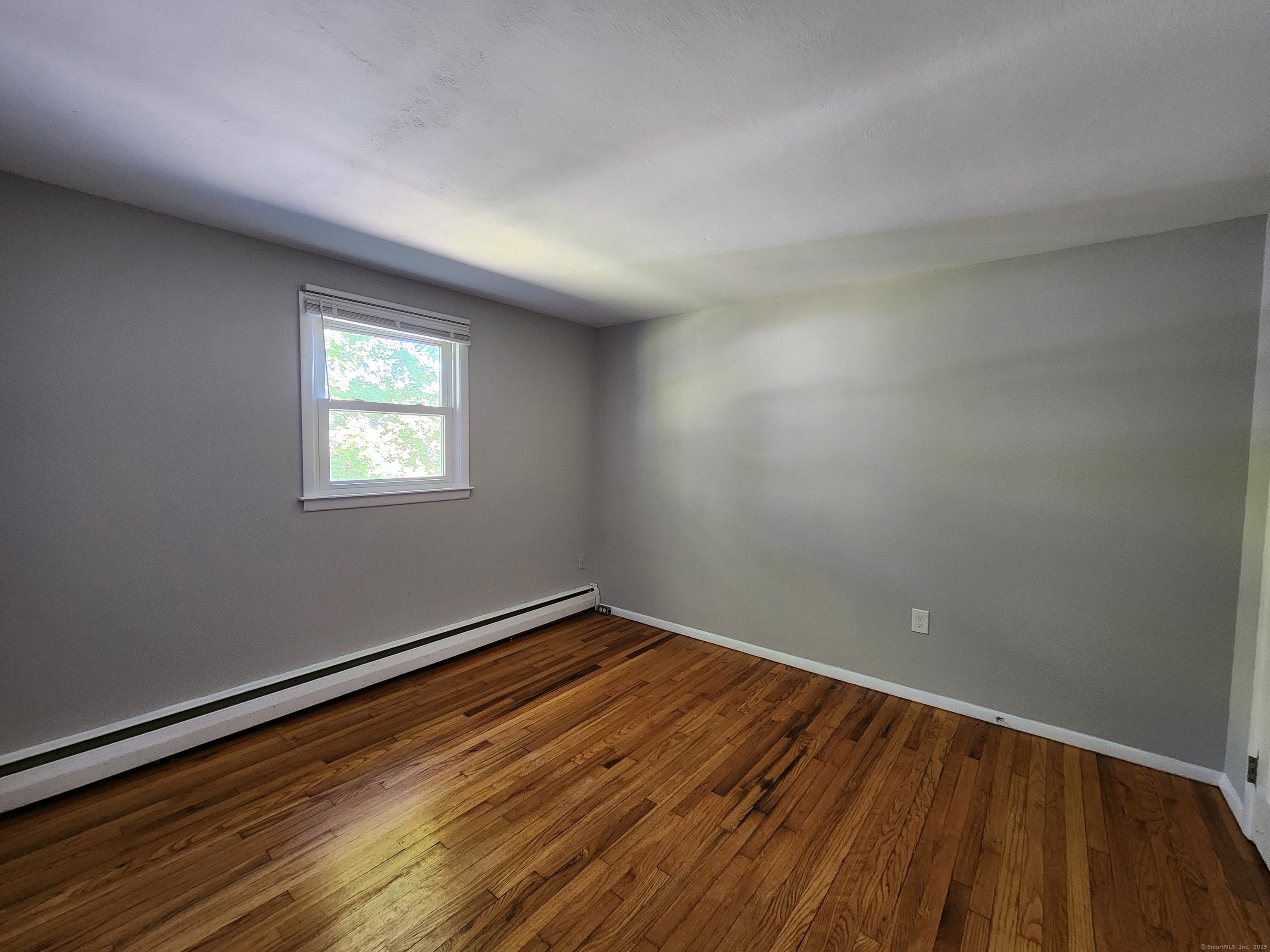 40 Durant Avenue, Unit B Bethel, CT 06801 - Photo 8 of 12 a view of an empty room with wooden floor and a window