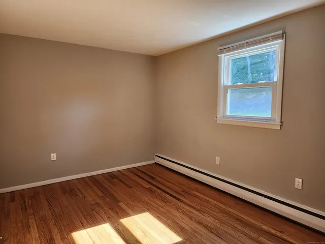 a view of a room with wooden floor and a window