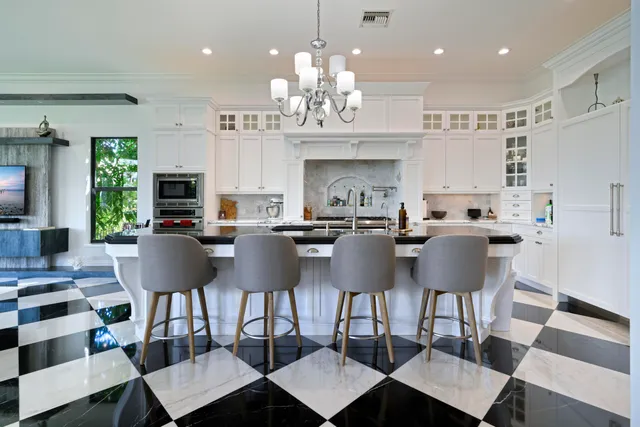 a kitchen with white cabinets and window