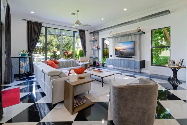 a living room with furniture a large window and a flat screen tv