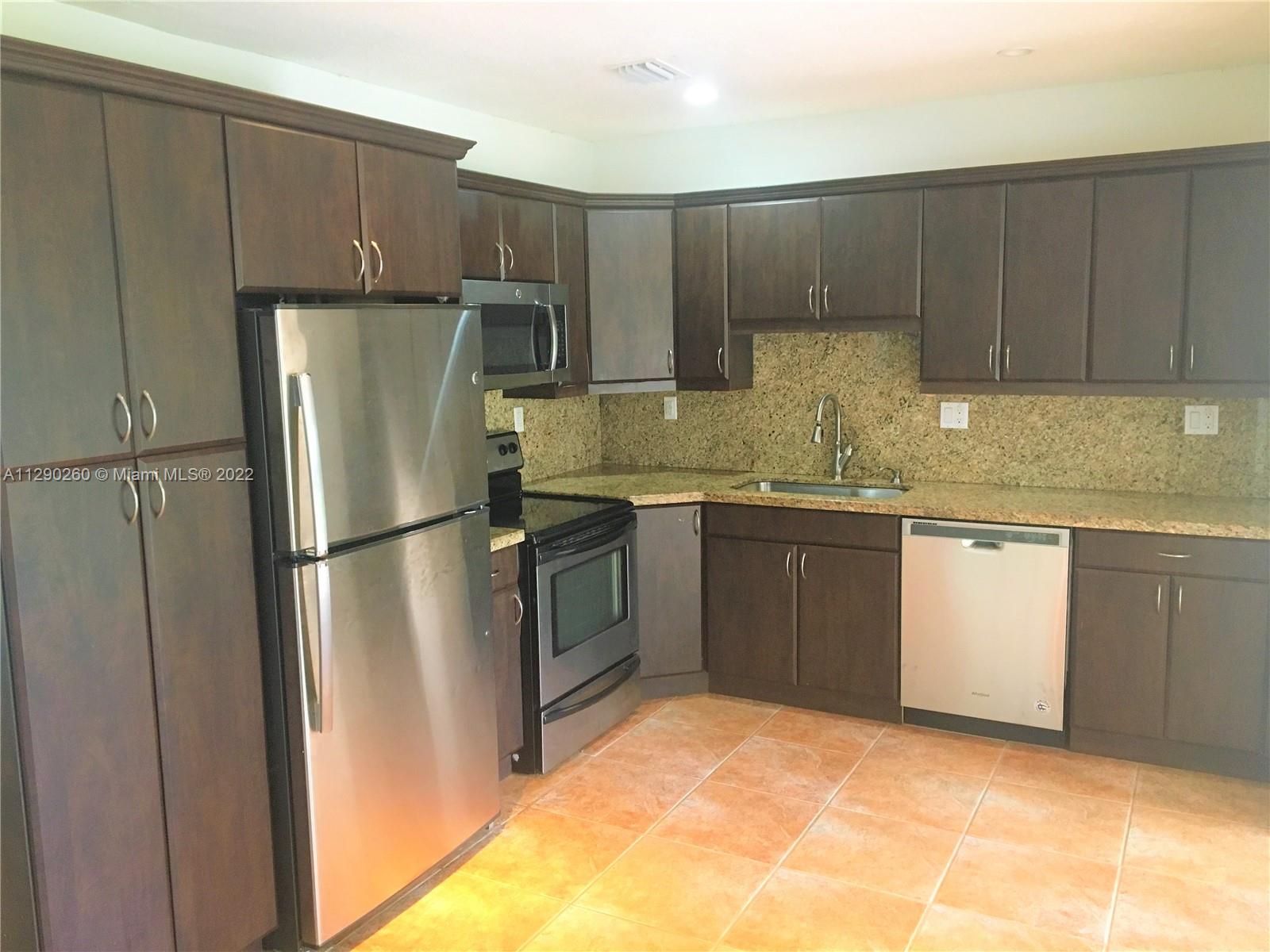 6442 Southwest 37th Street Miami, FL 33155 - Photo 2 of 14 a kitchen with a sink a stove a refrigerator and cabinets