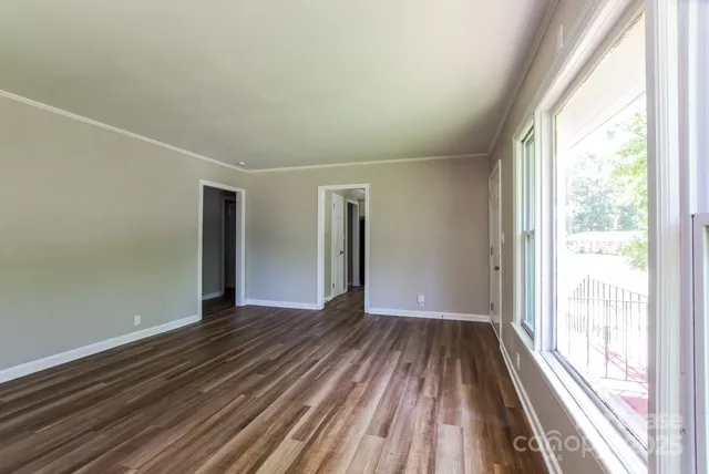 a view of a room with wooden floor and large windows