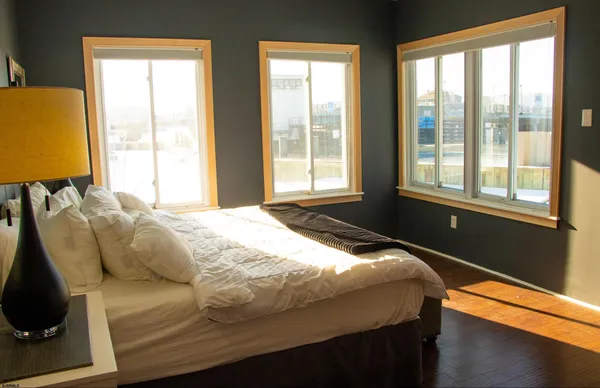 a bedroom with a bed and wooden floor