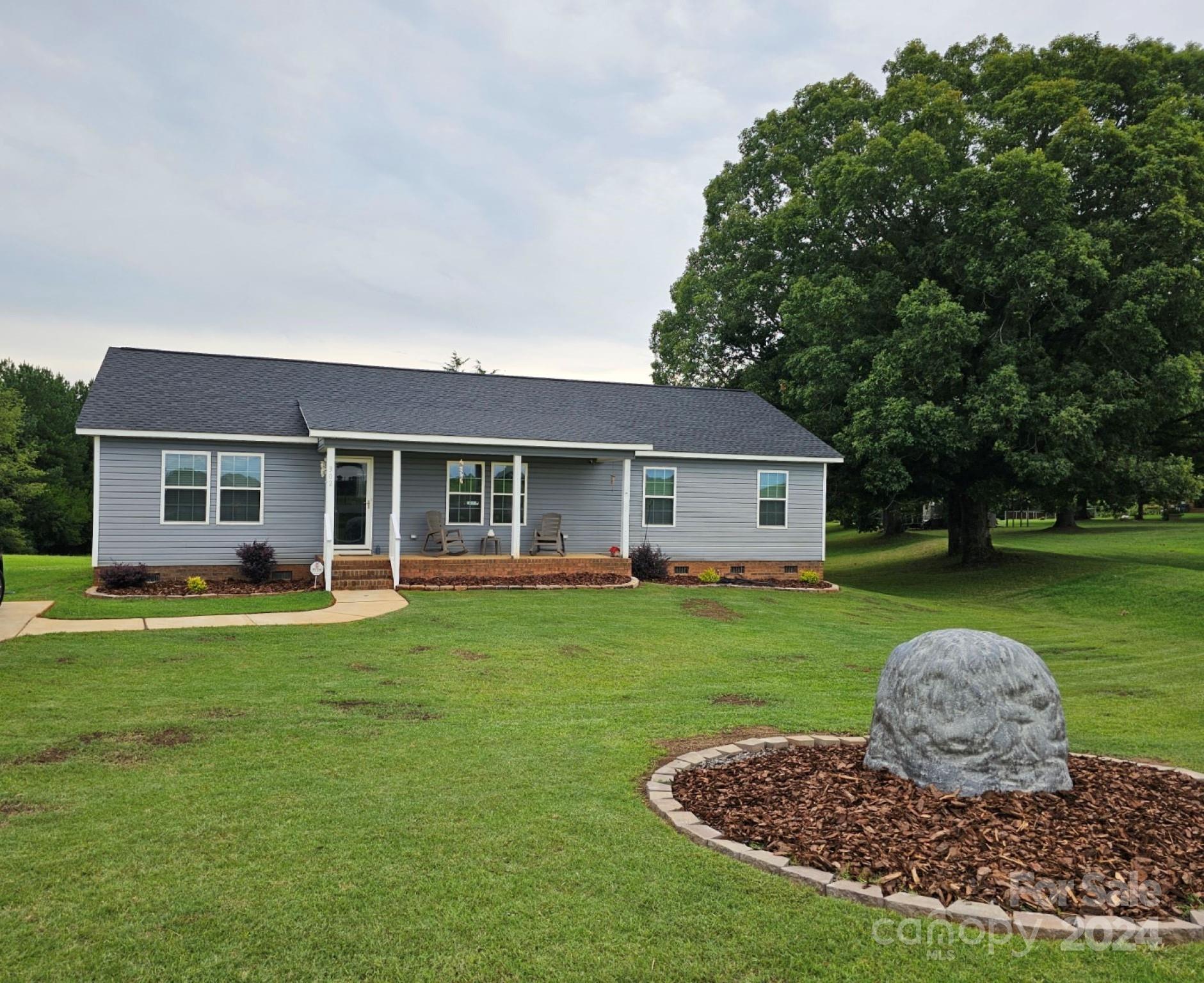 302 Flint Hill Road Cherryville, NC 28021 - Photo 1 of 32 a front view of house with a garden and trees