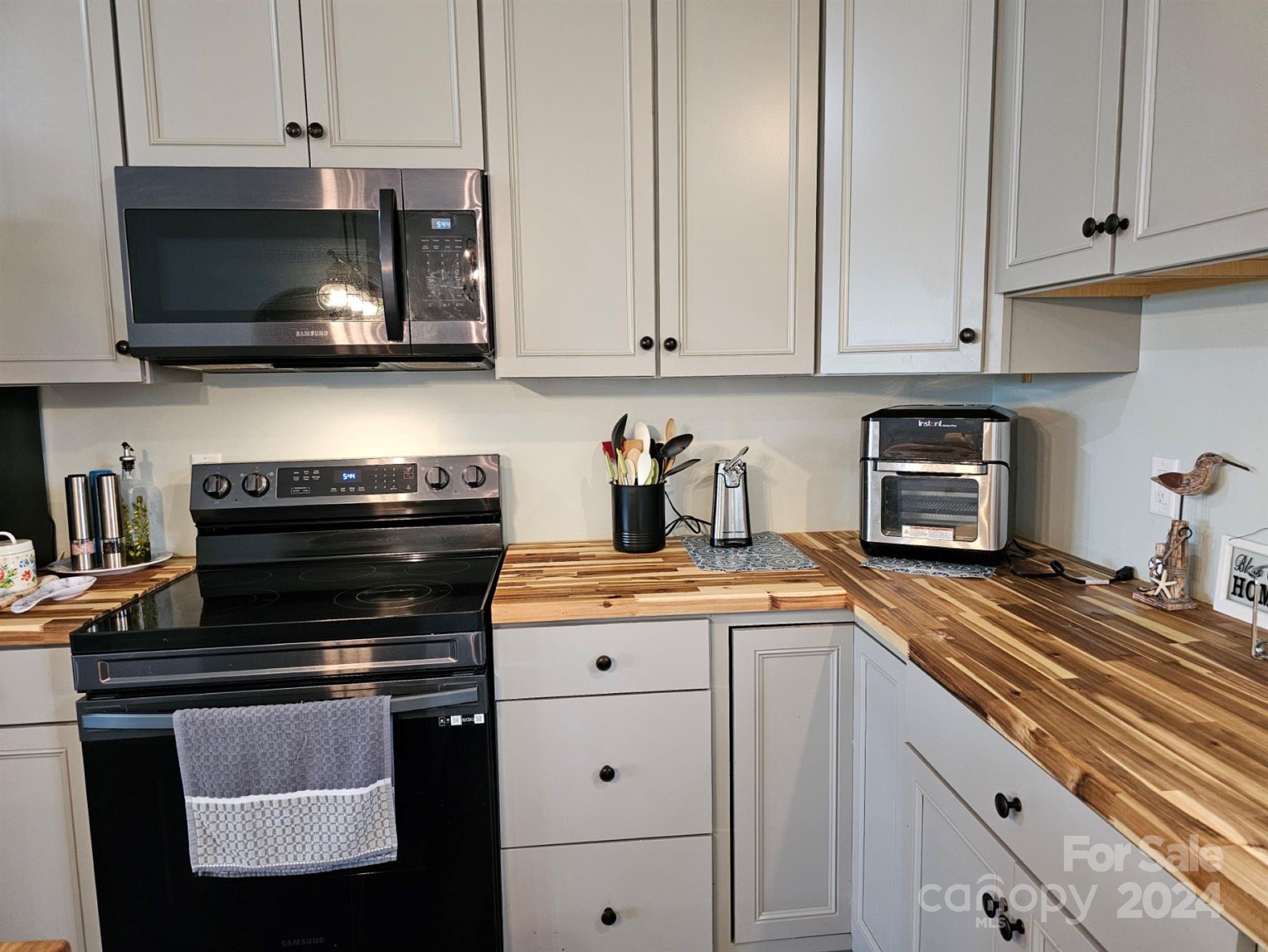 302 Flint Hill Road Cherryville, NC 28021 - Photo 14 of 32 a kitchen with stainless steel appliances granite countertop a stove a microwave and cabinets