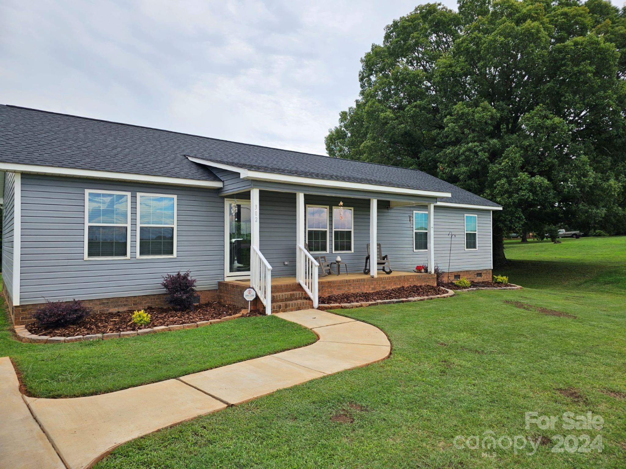 302 Flint Hill Road Cherryville, NC 28021 - Photo 3 of 32 a front view of house with a garden and patio