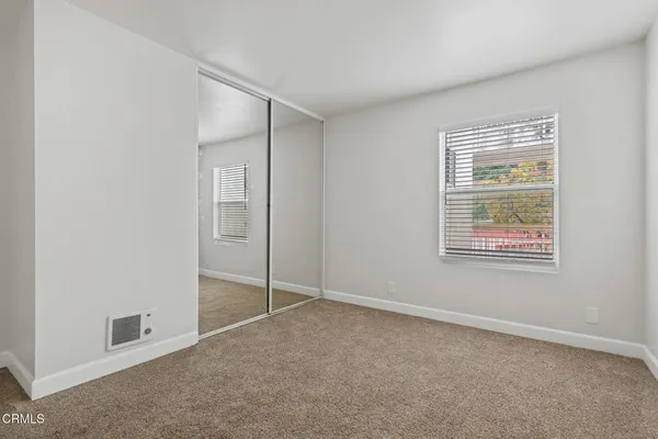 an empty room with windows and closet