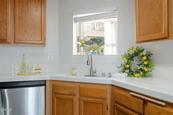a kitchen with stainless steel appliances granite countertop a sink a potted plant and a window