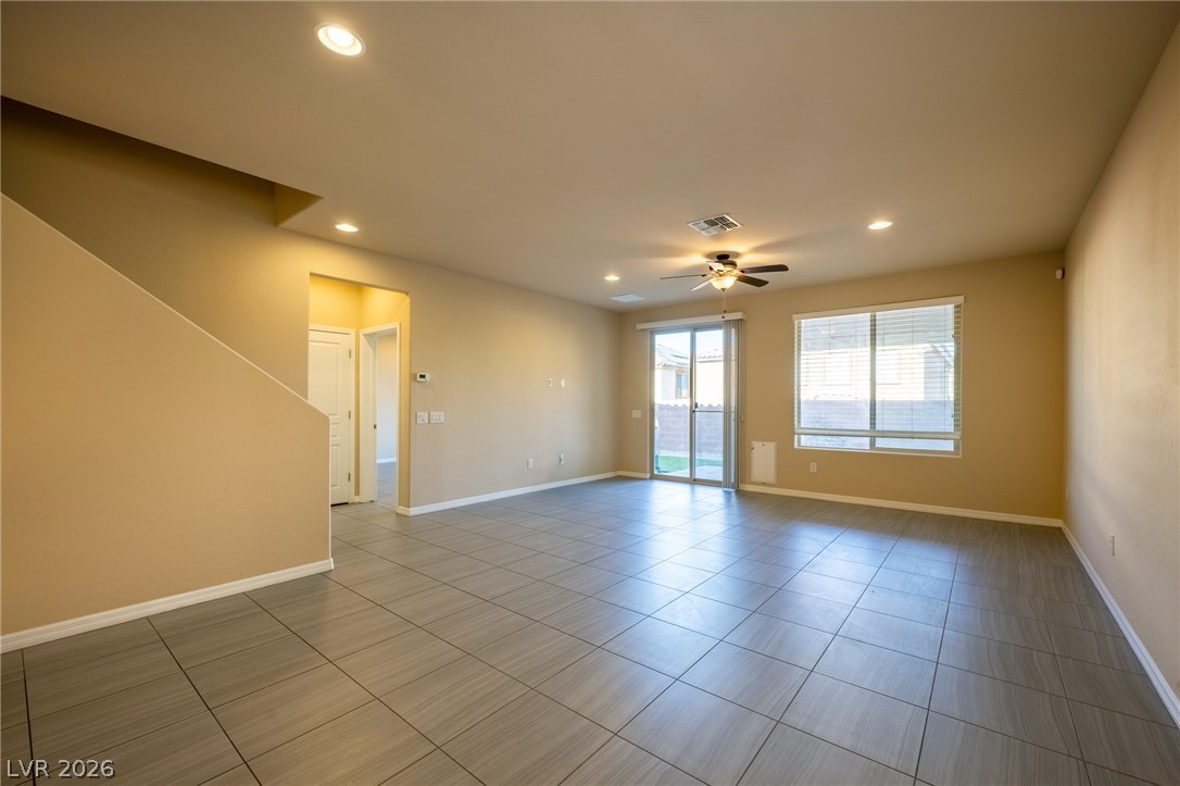 11016 Prairie Grove Road Las Vegas, NV 89179 - Photo 11 of 37 A spacious, naturally illuminated living area featuring sleek tile flooring and convenient outdoor access.