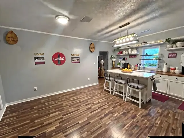 a room with stainless steel appliances lots of wooden furniture