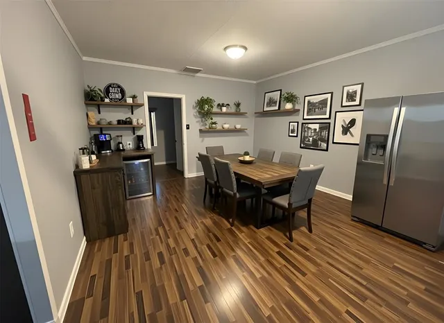 a view of a dining room with furniture a rug and wooden floor