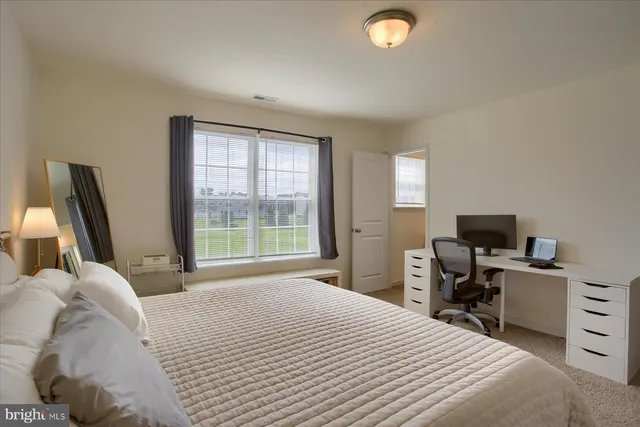 a bedroom with a bed and a computer on the desk