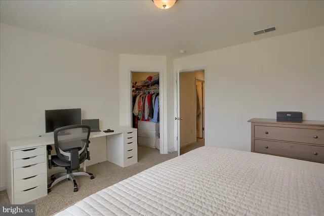 a bedroom with a bed and a desk
