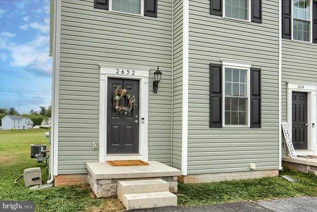 a small white and wooden bench sitting in front of a house