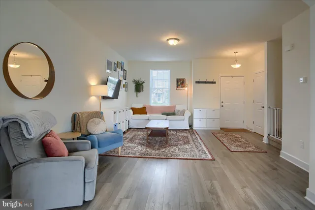 a living room with furniture and a wooden floor
