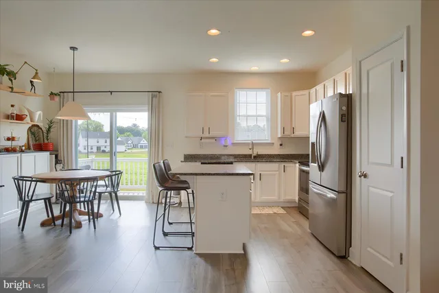 a kitchen with a table chairs refrigerator and window