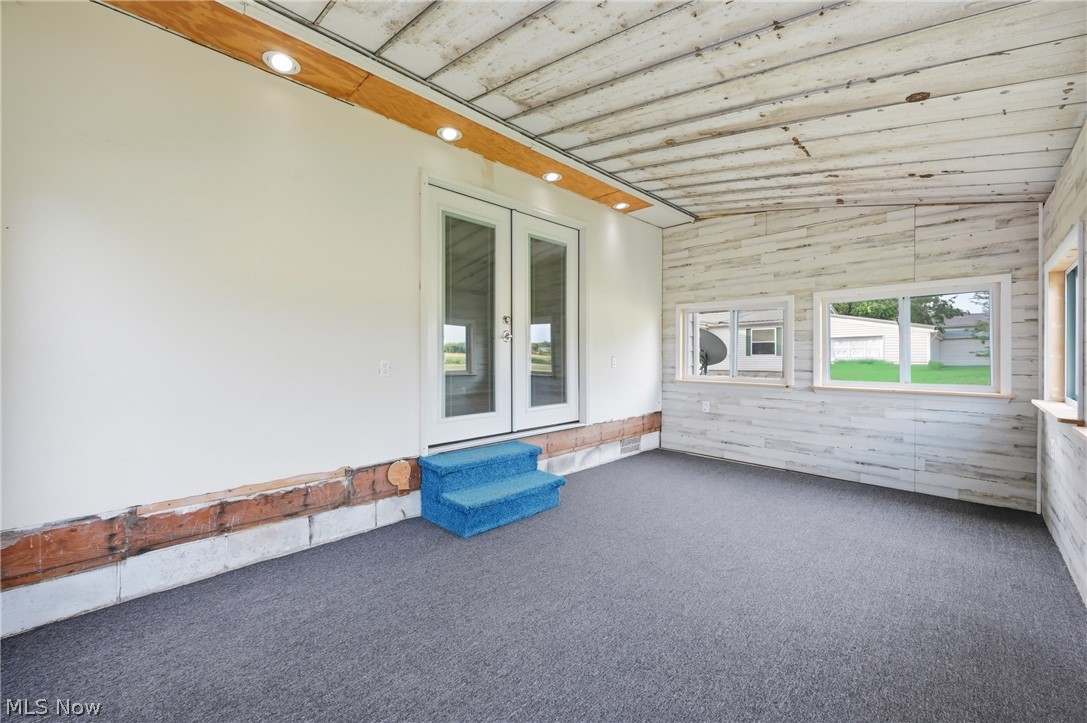 4570 Pymatuning Lake Road Andover, OH 44003 - Photo 12 of 38 Sunroom featuring white double French doors, recessed lighting, distressed wood-finish paneling, and gray carpeting