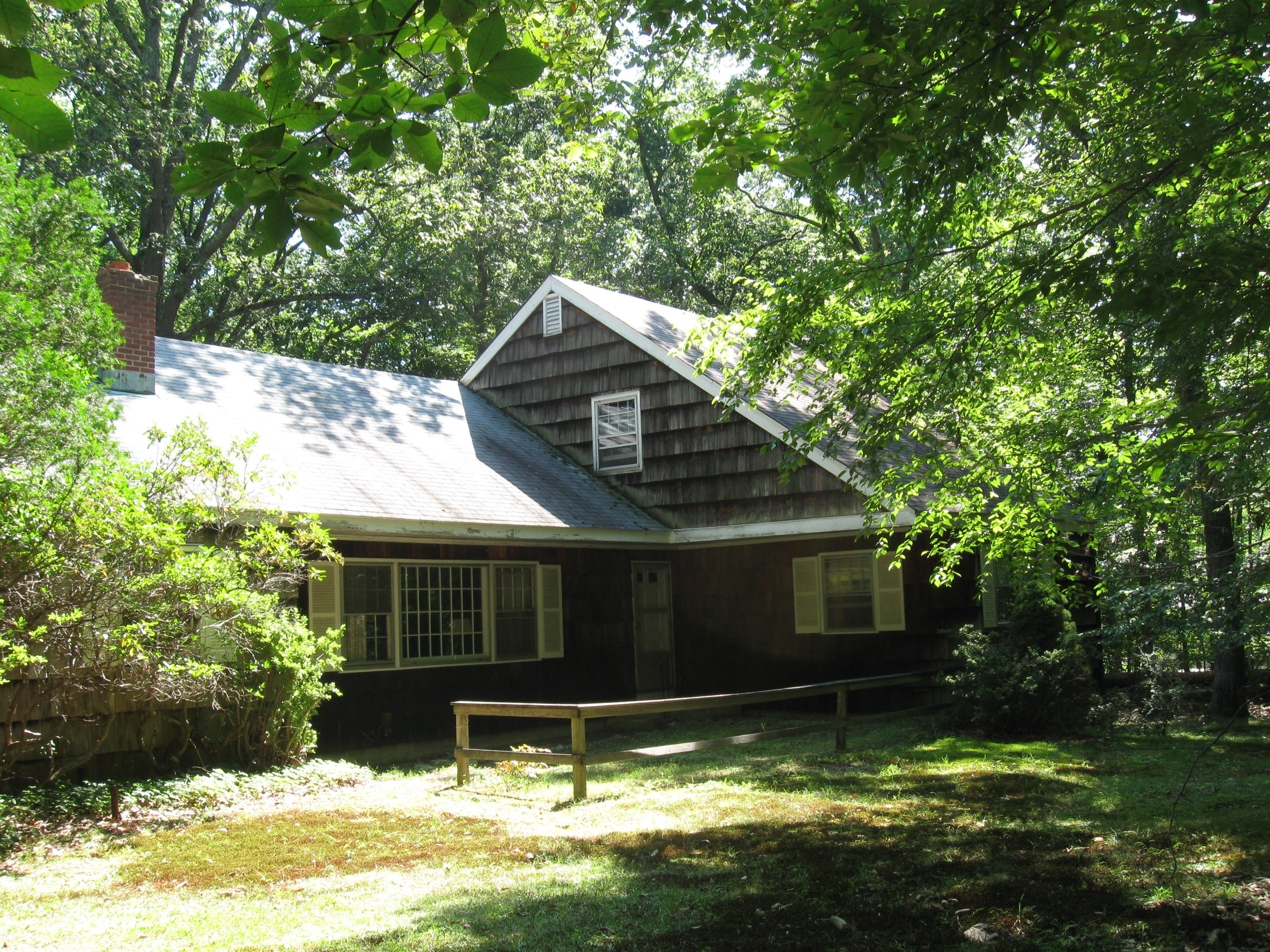 a view of a house with a yard balcony and a tree