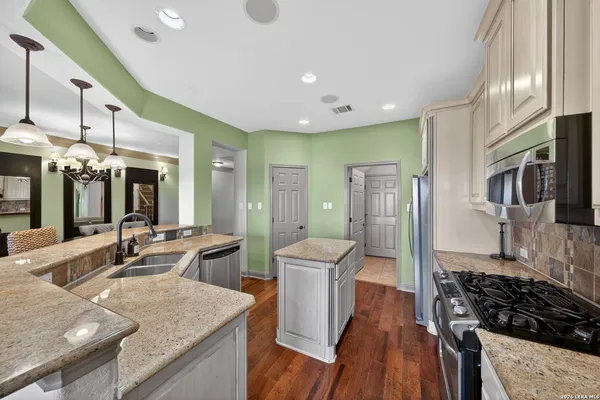 a kitchen with stainless steel appliances granite countertop sink stove and refrigerator