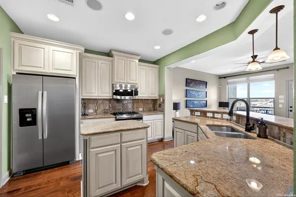 a kitchen with stainless steel appliances granite countertop a stove refrigerator sink and cabinets