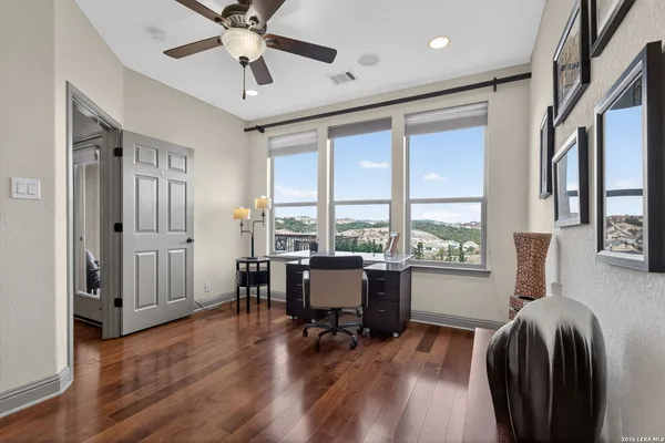 a living room with furniture and a wooden floor next to a window