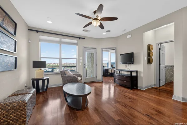 a living room with furniture flat screen tv and wooden floor
