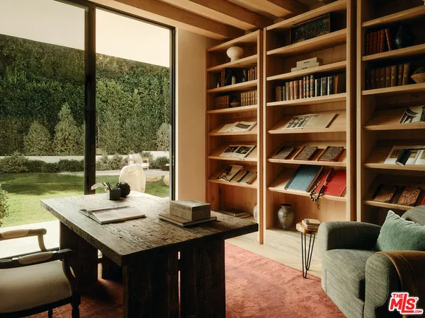 a view of a workspace with furniture and a bookshelf