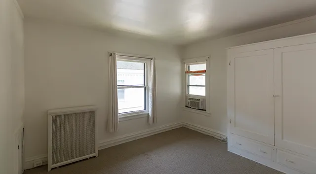 an empty room with windows and closet