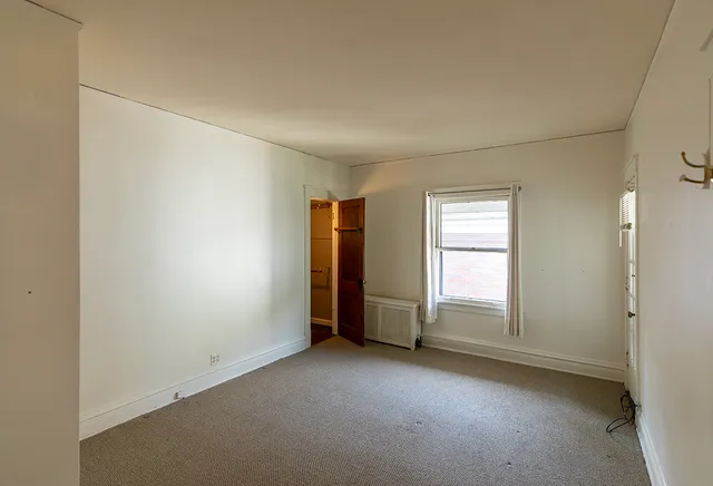 an empty room with windows and closet