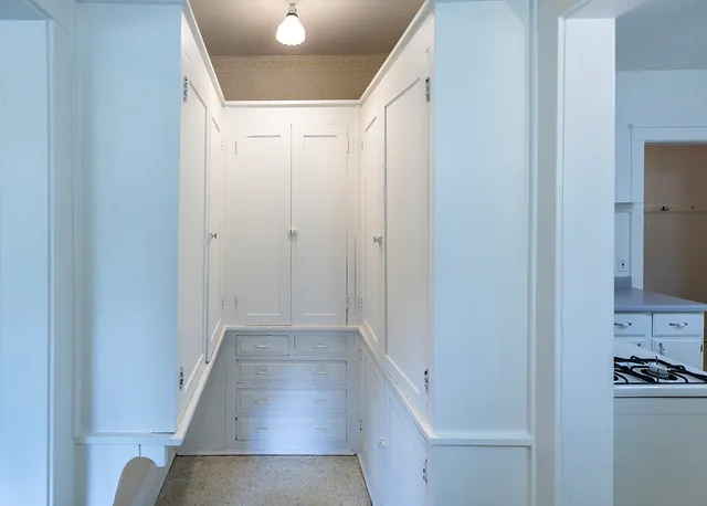 a view of a hallway with wooden floor and a sink