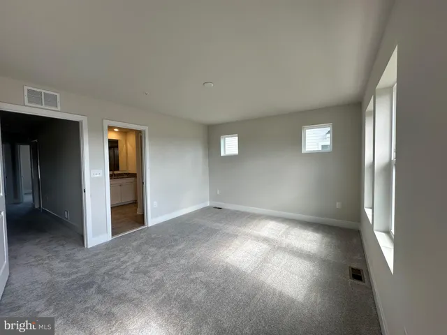an empty room with windows and closet