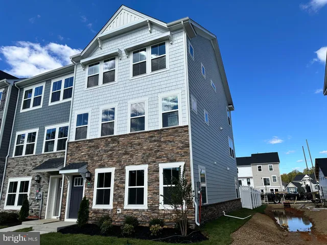 a front view of a house with yard and parking